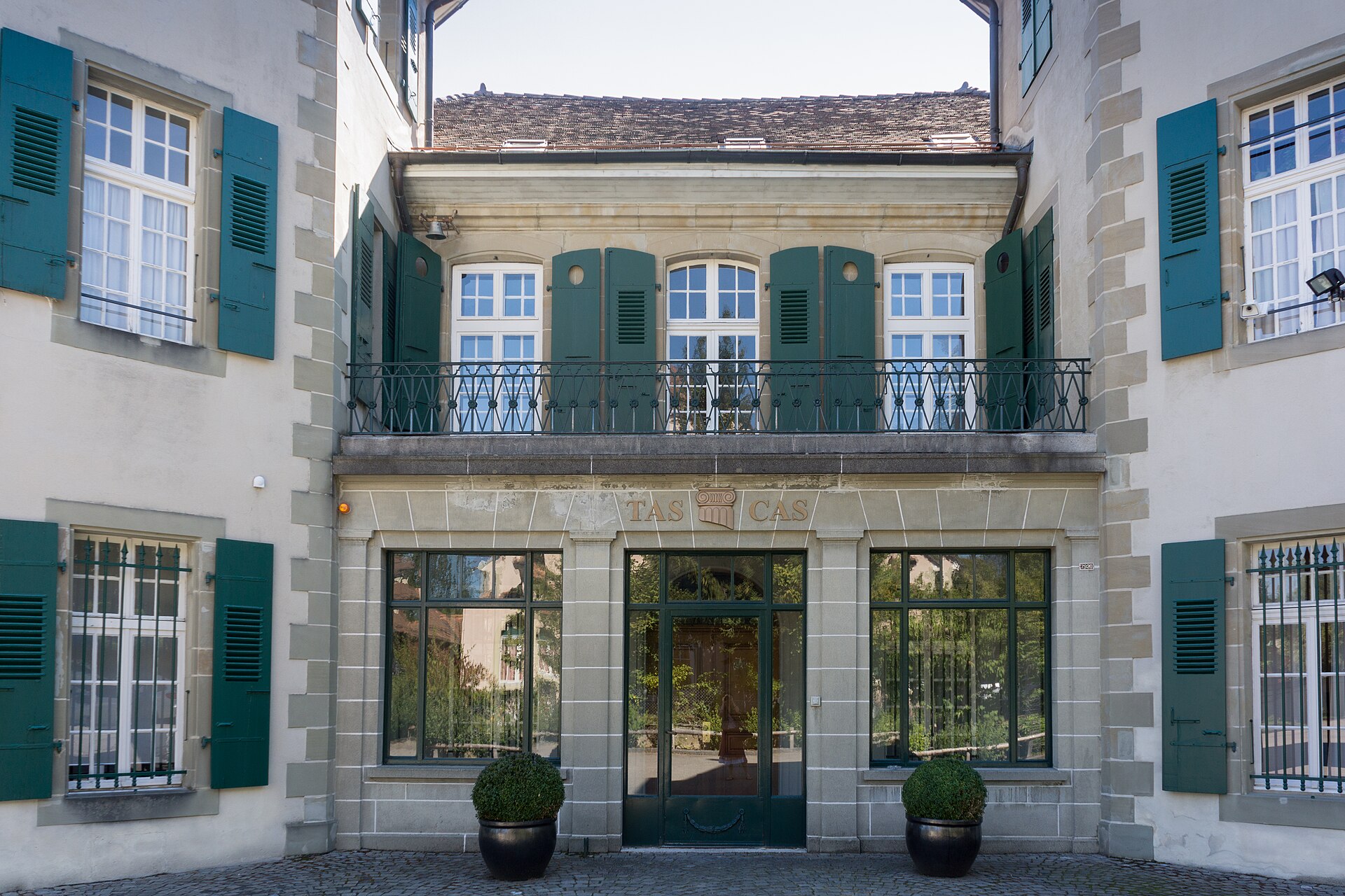 The exterior of a building with TAS CAS written above the door.