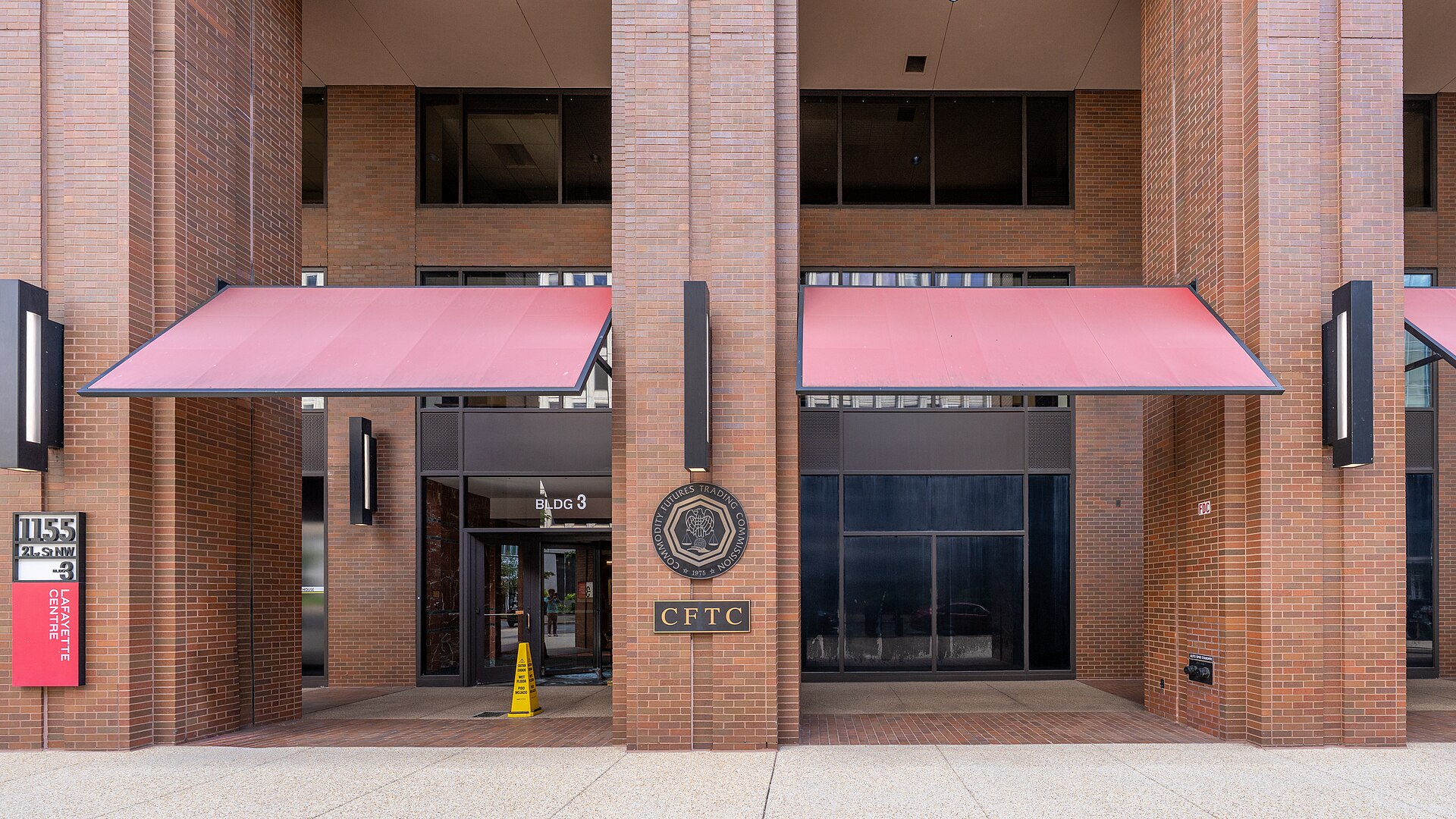 The Commodity Futures Trading Commission (CFTC) building with a sign that reads CFTC and the CFTC seal.
