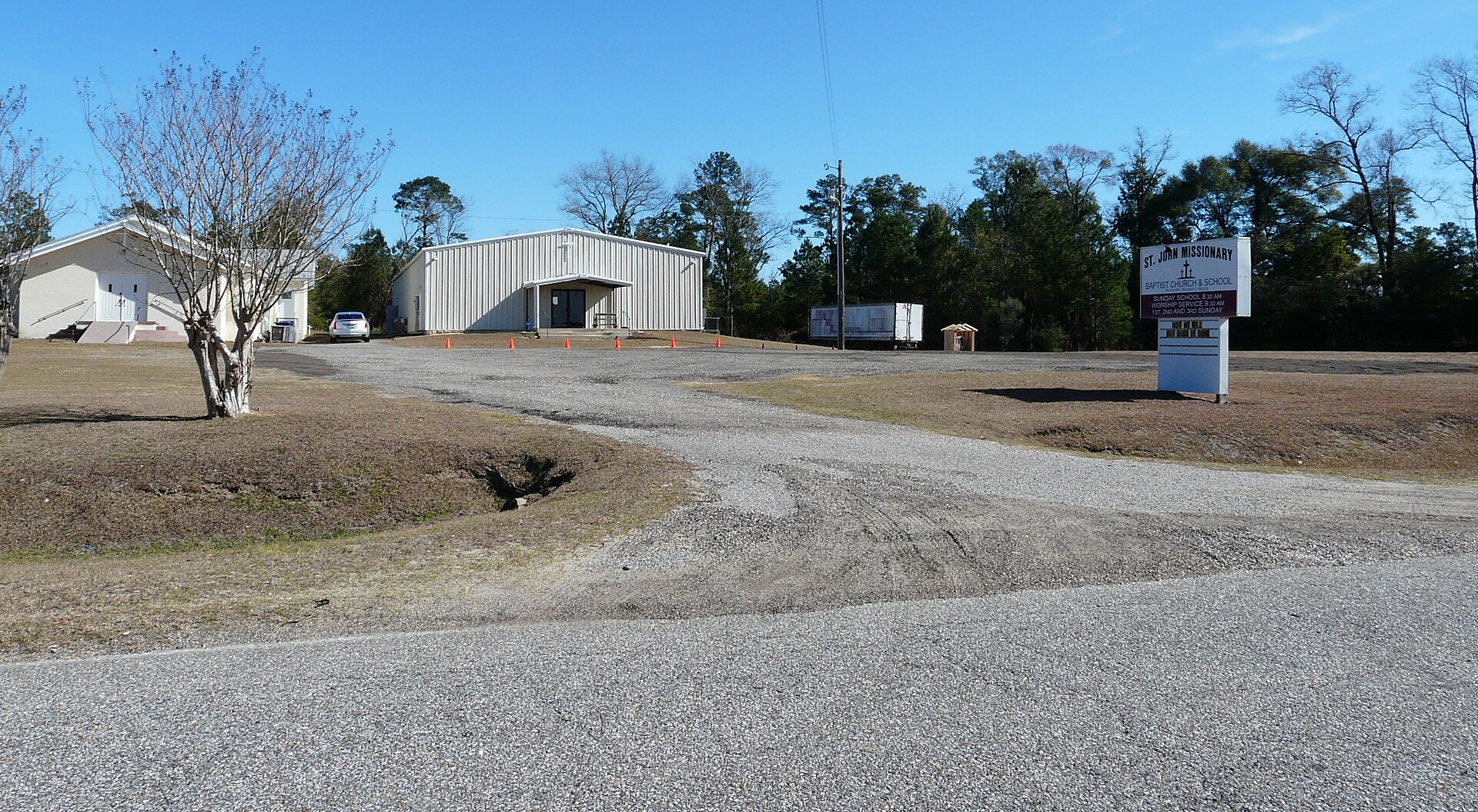 A photo of a church parking lot with a sign that reads St. John Missionary Baptist Church & School.