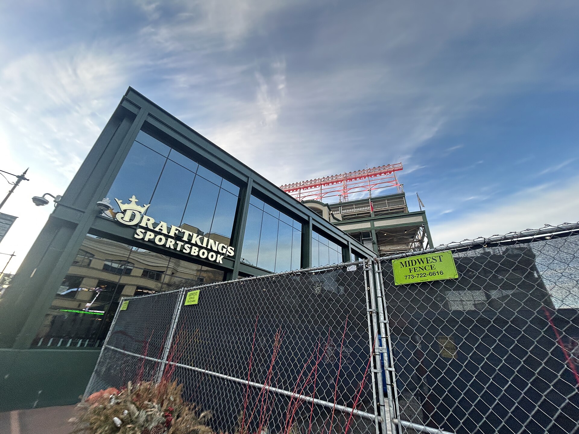 DraftKings Sportsbook sign on building behind chain link fence