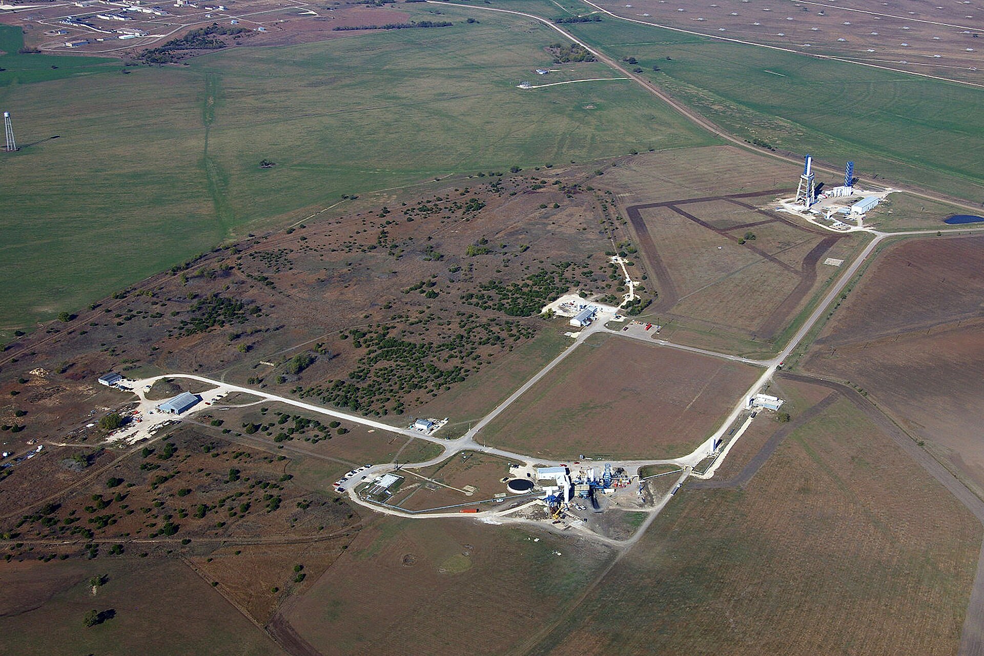 An aerial view of a SpaceX Starbase facility with launchpads and buildings.