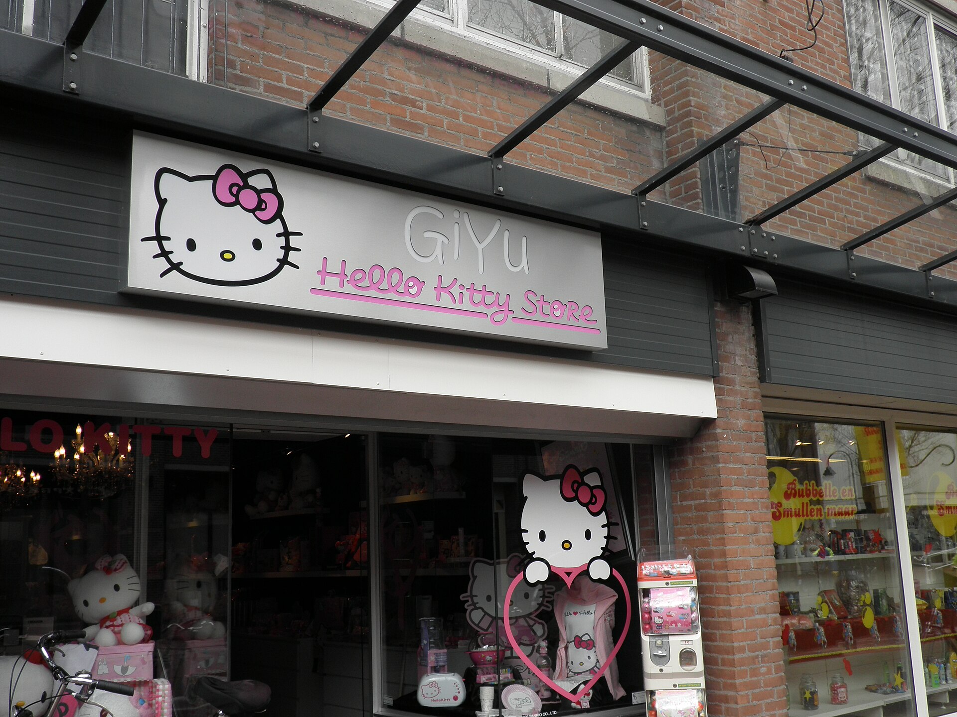 A sign for a Hello Kitty store with the character's face and the words "Giyu Hello Kitty Store" above the entrance.