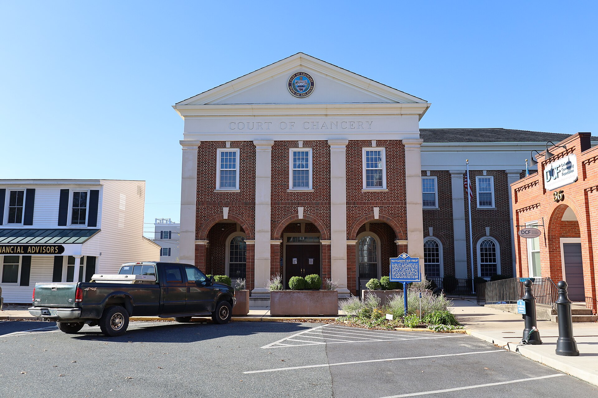 Court of Chancery building with brick and white facade, three arched doorways, and a seal above the entrance.