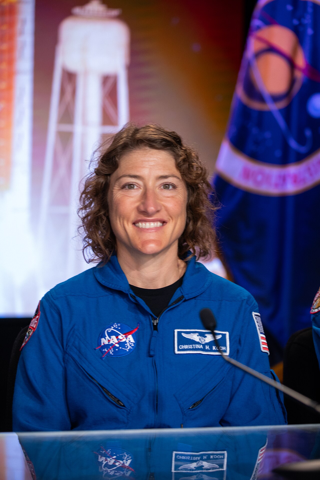 NASA astronaut Christina Koch wearing a blue flight suit with NASA patches