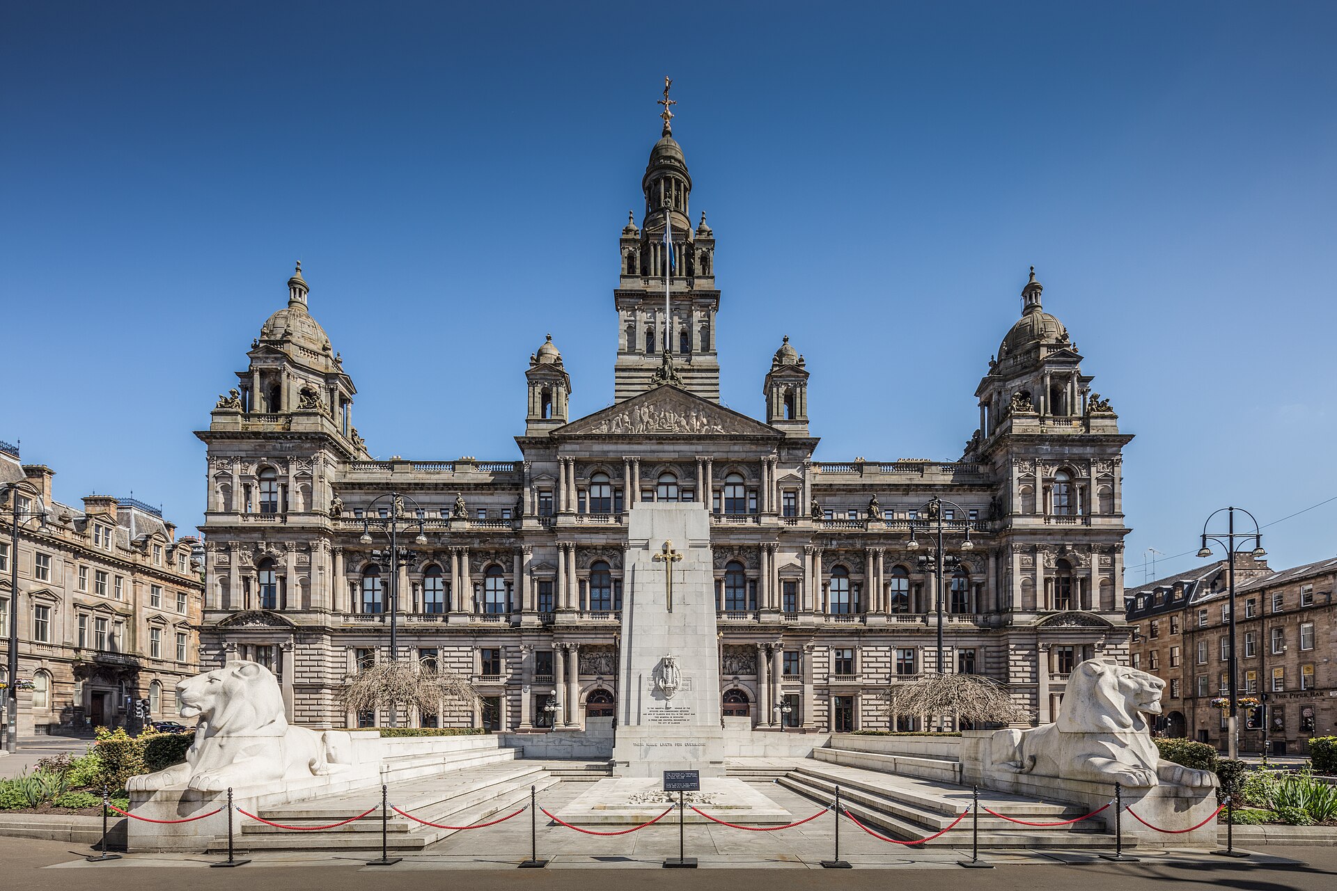 Glasgow City Chambers with two large stone lions and a monument in front
