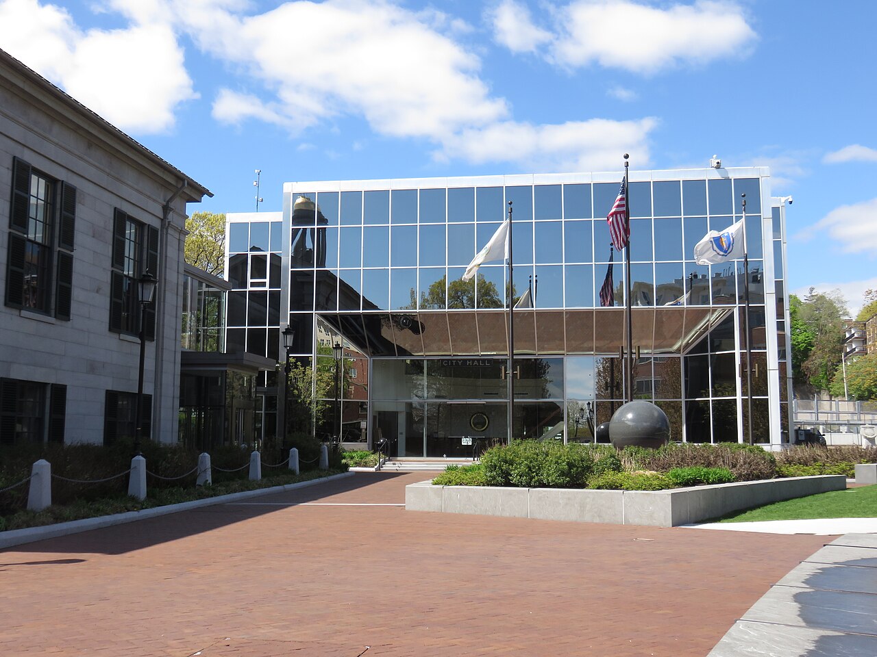 A large building with a glass facade and flags in front of it.