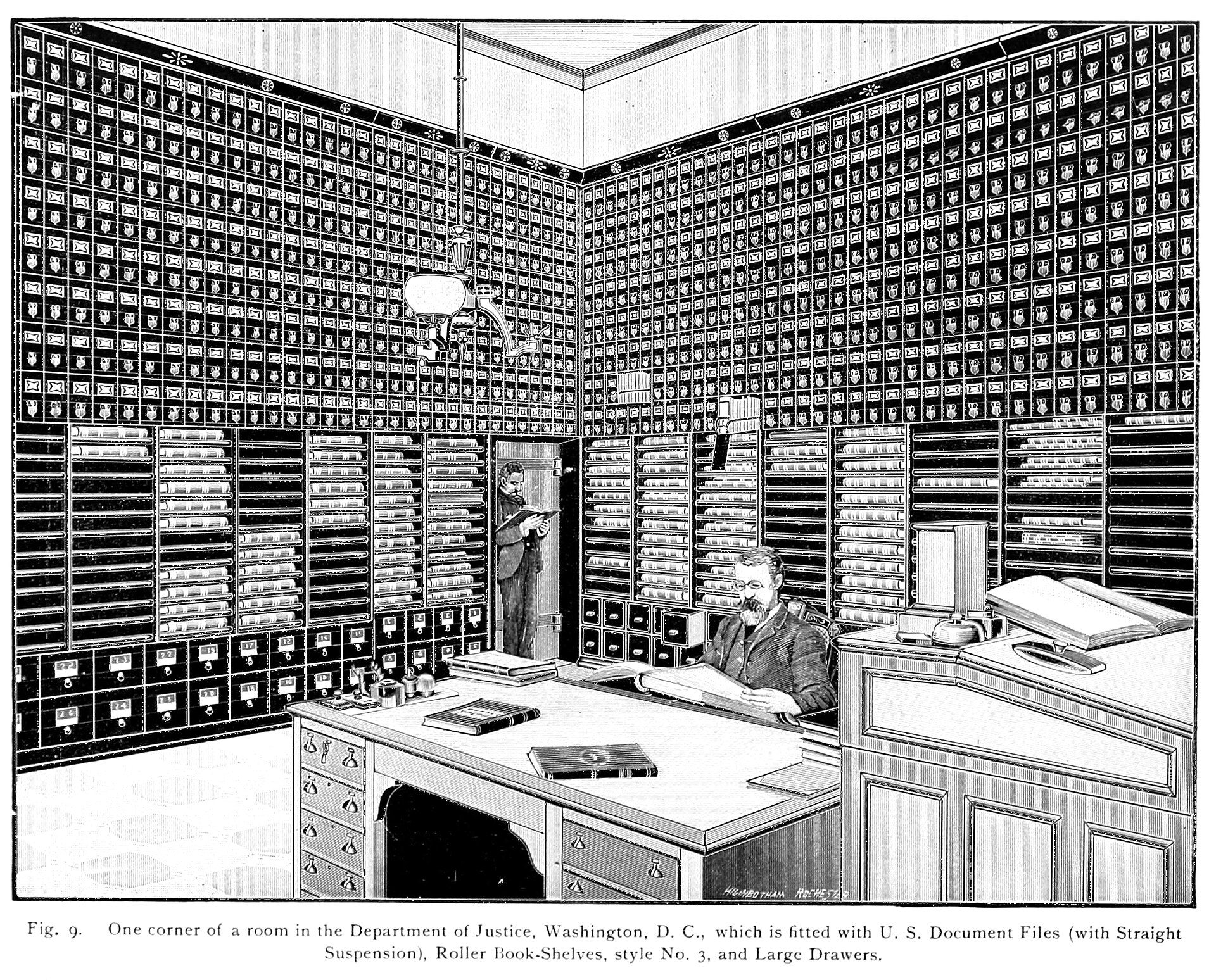 A man sits at a desk in a room filled with filing cabinets and roller book-shelves, with another man standing and reading a document in the background. The caption identifies the location as a corner of the Department of Justice, Washington, D.C.