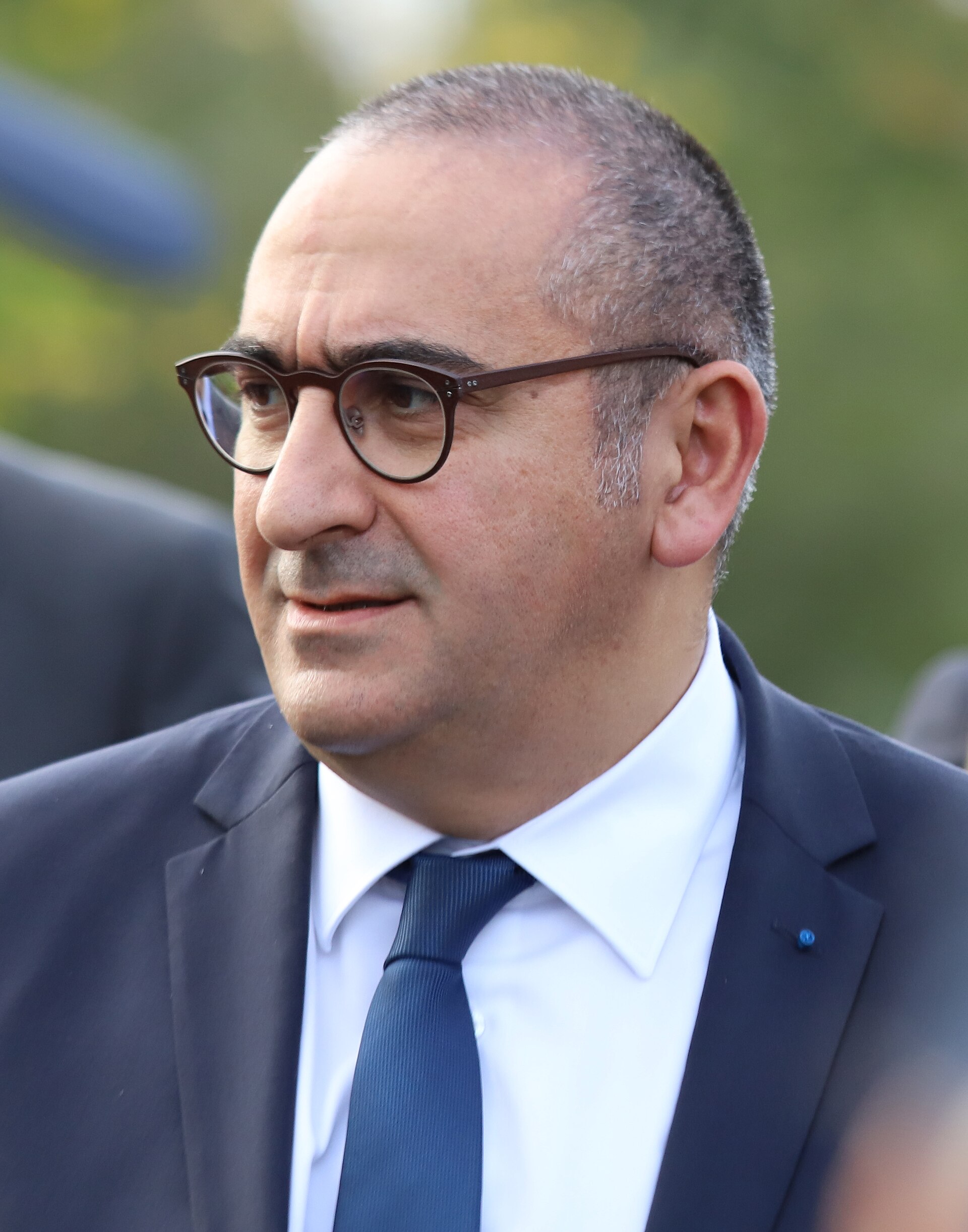 Laurent Nuñez, a middle-aged man with short graying hair, wearing a dark suit, white shirt, dark tie, and black-framed glasses, looking to the left.