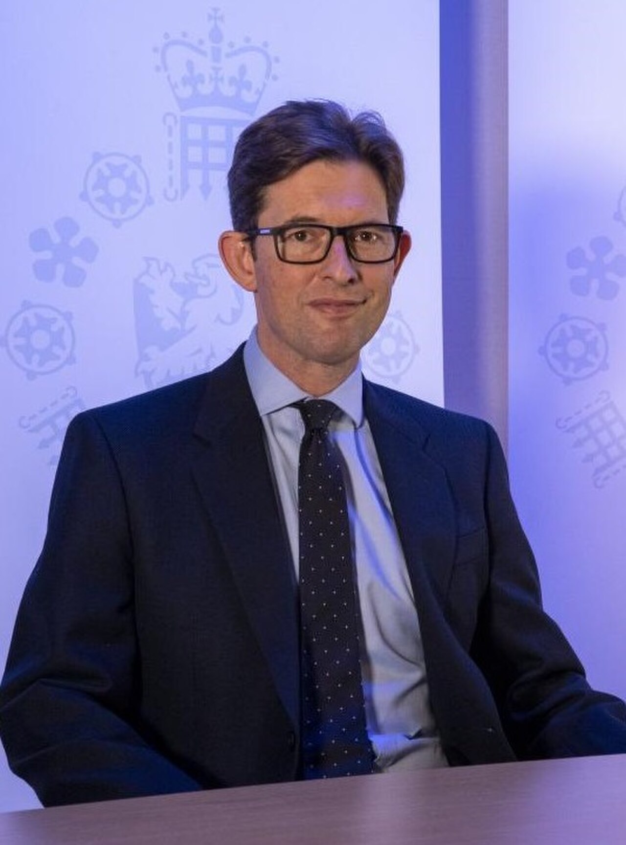 A man in a suit and tie sitting at a table