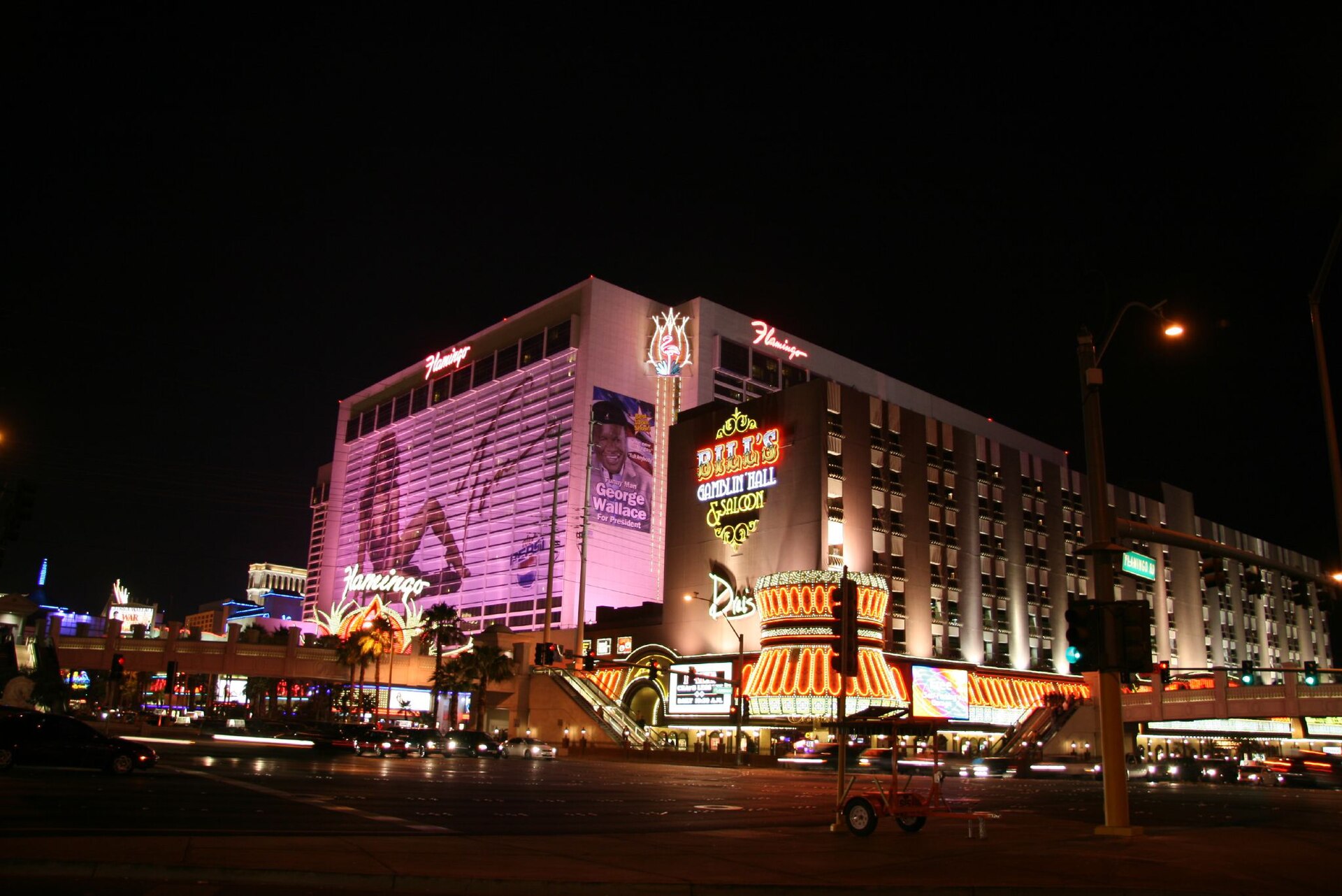 The Flamingo Las Vegas Hotel and Casino at night, with its iconic neon signs and illuminated facade.