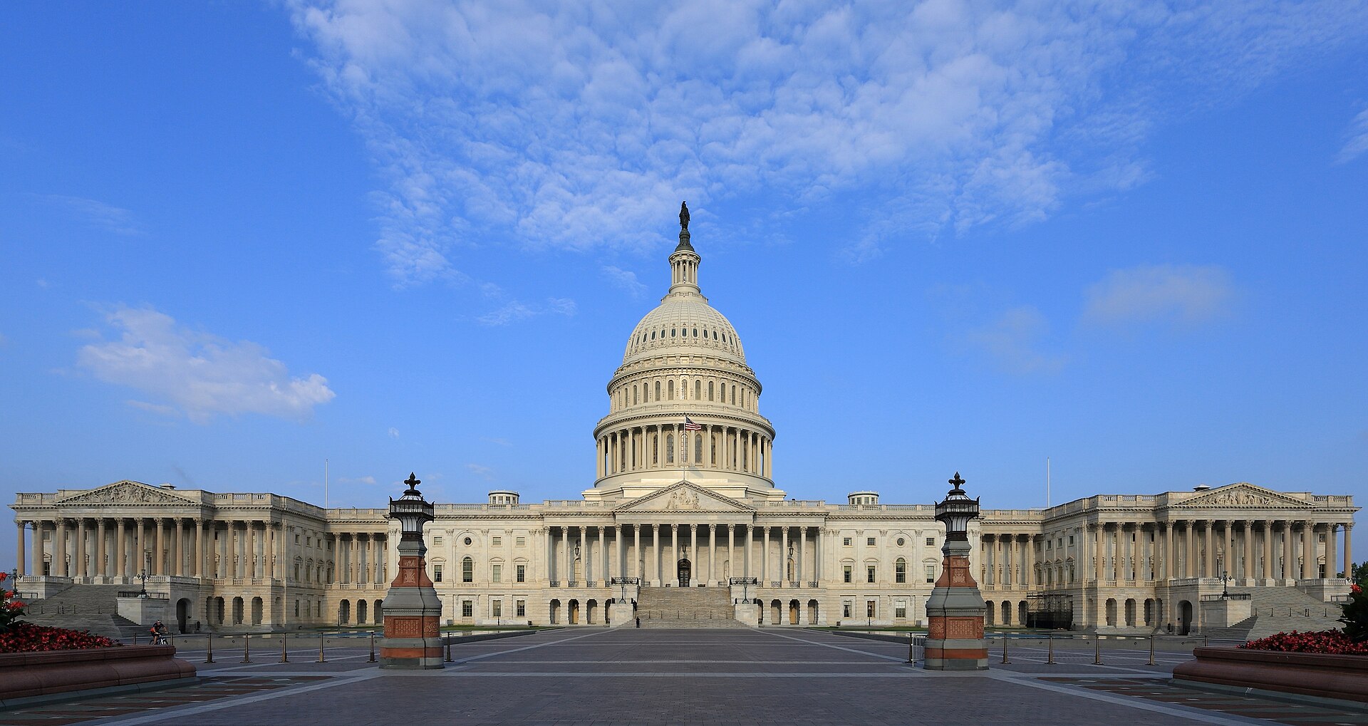 The US Capitol building with a blue sky and clouds in the background