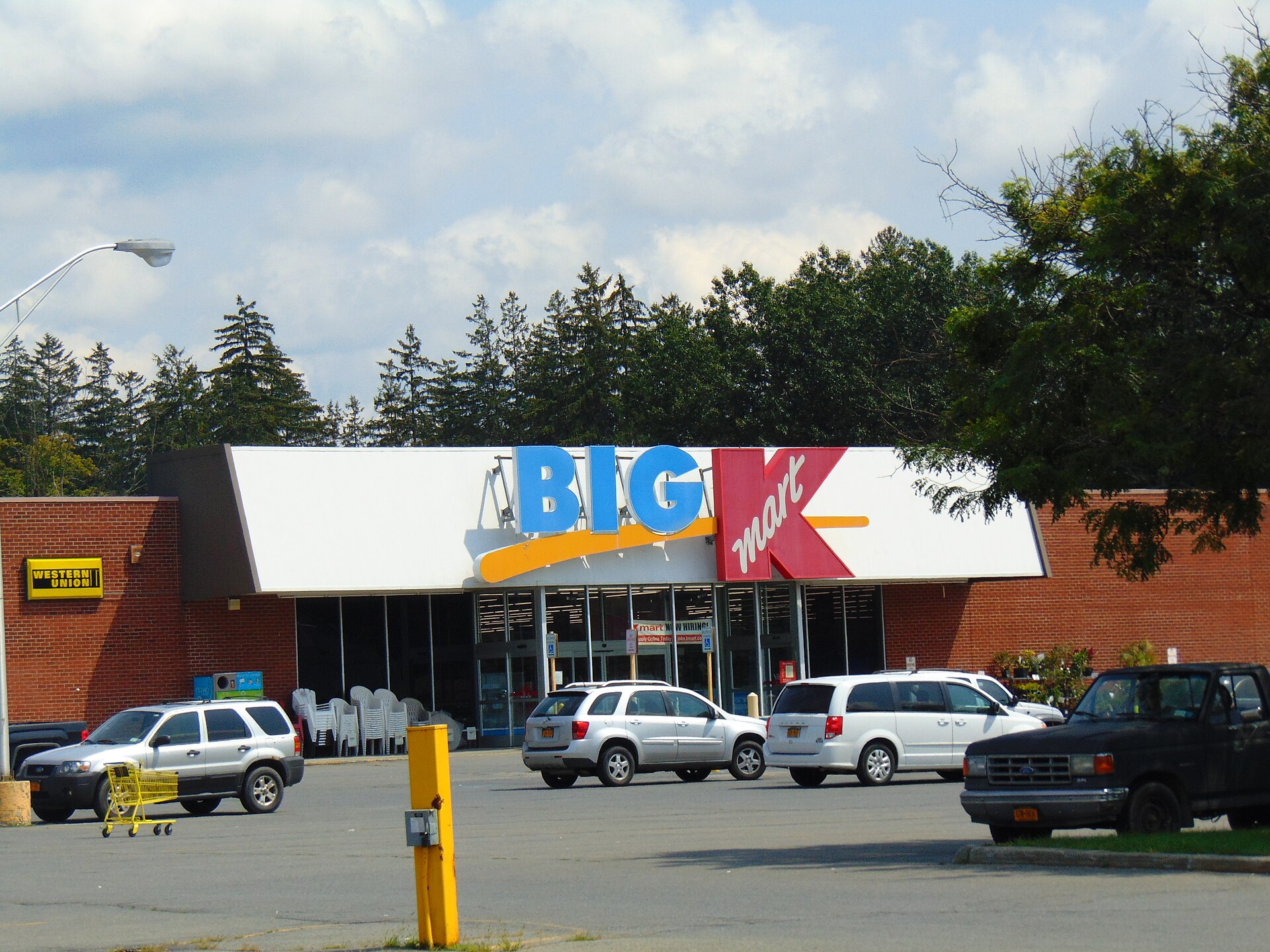 A Kmart store with a parking lot and several cars parked outside.