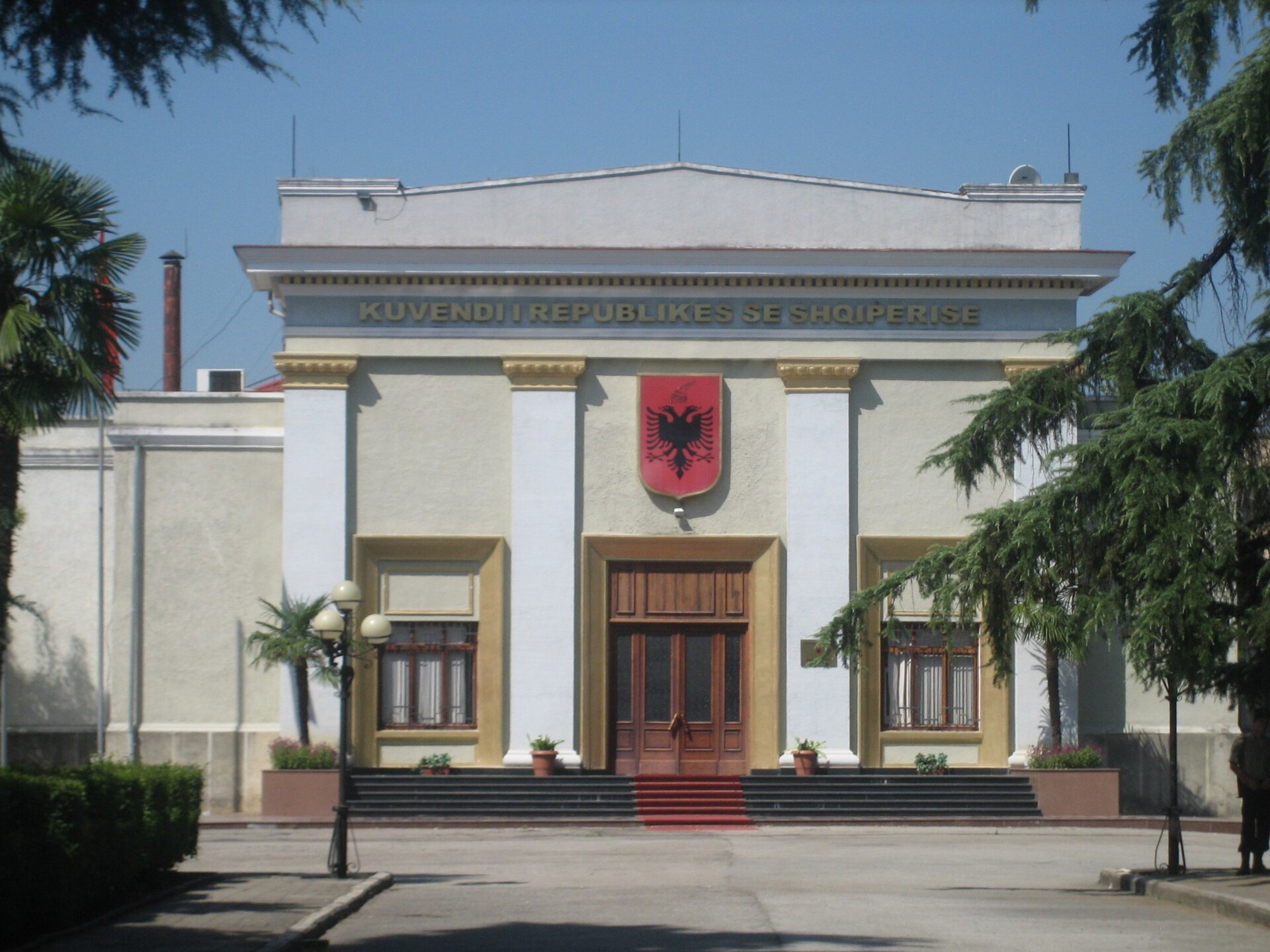 The Parliament of the Republic of Albania building with the Albanian coat of arms above the entrance.
