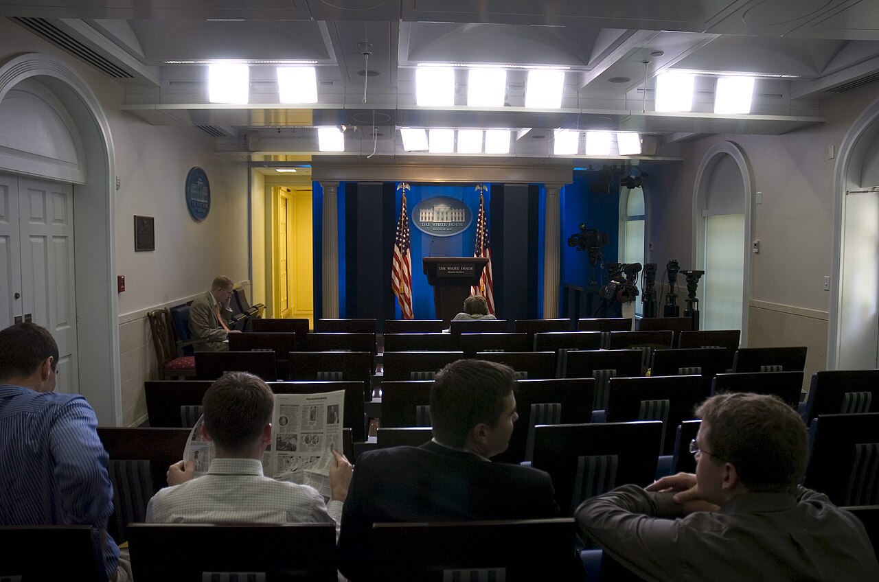 The James S. Brady Press Briefing Room with the White House podium, flags, and rows of press seats