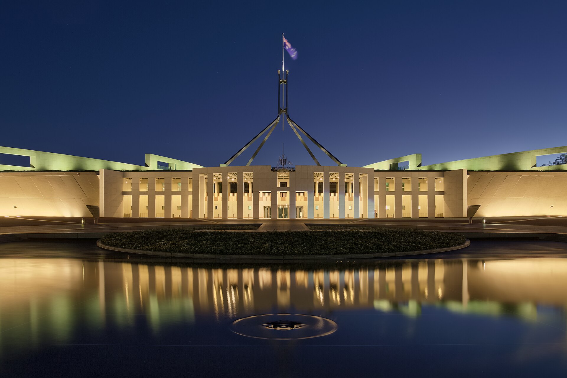 Australian Parliament House at dusk with flag flying