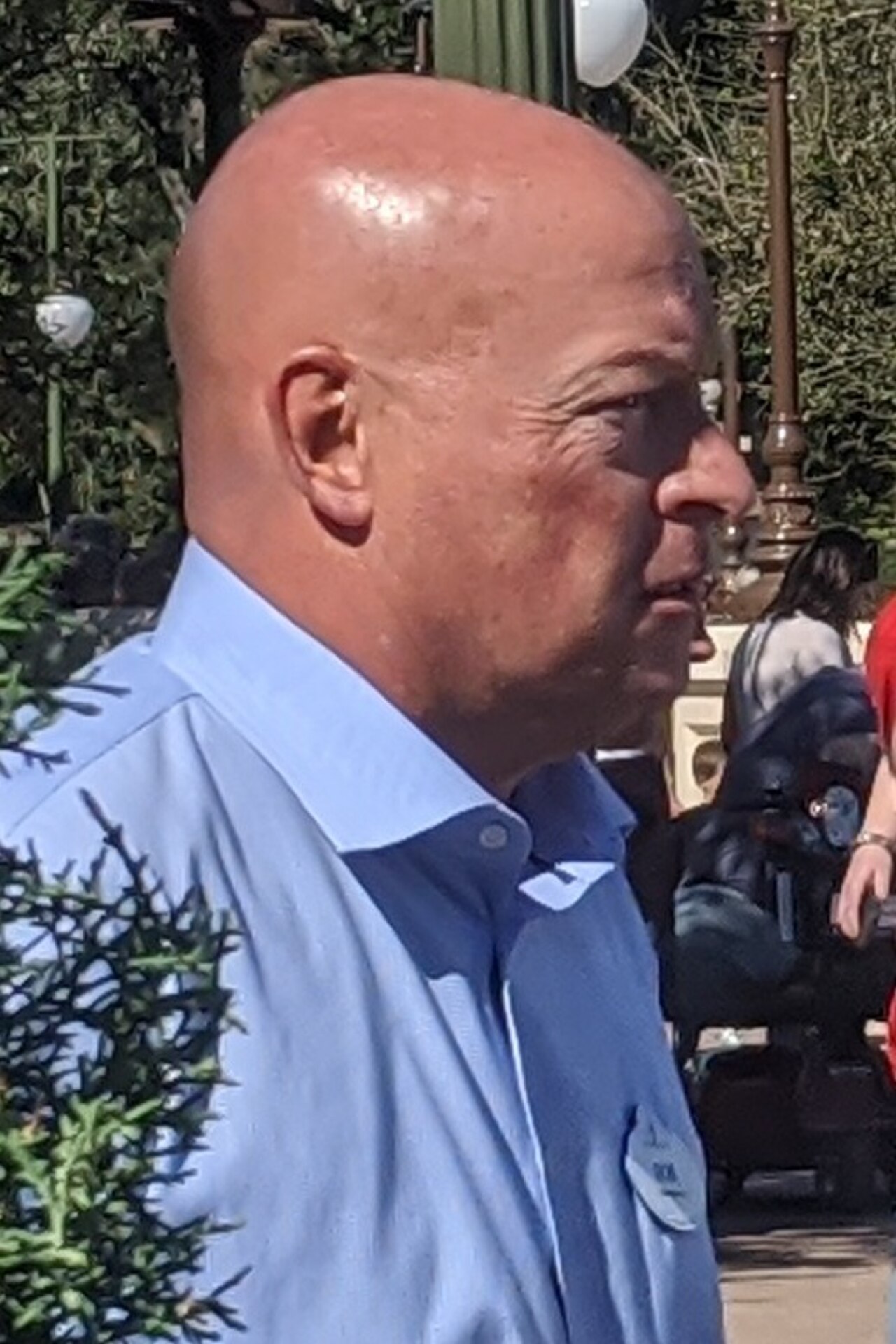 close-up of a bald man in a blue collared shirt