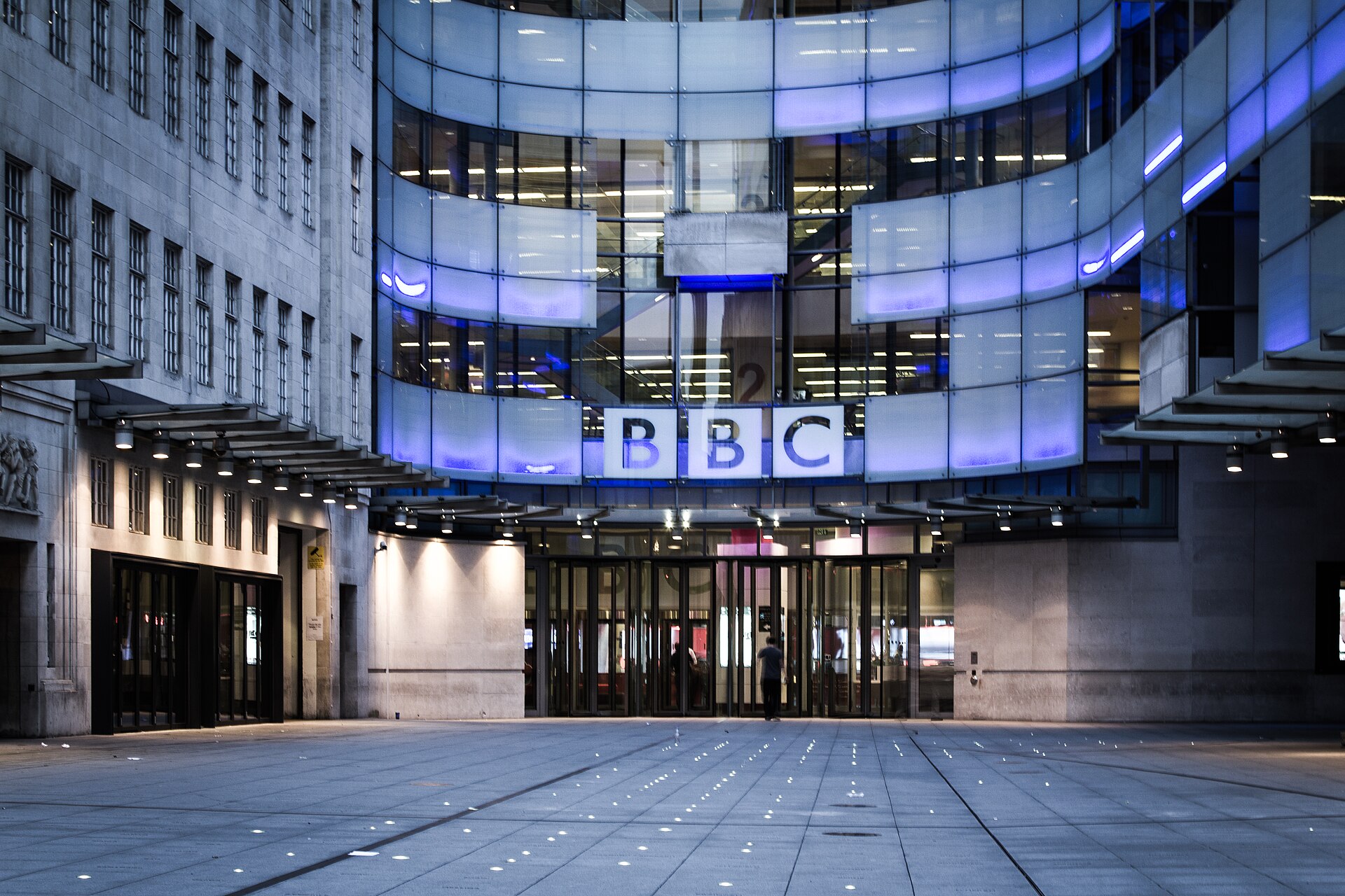 A building with a glass facade and a sign that reads BBC