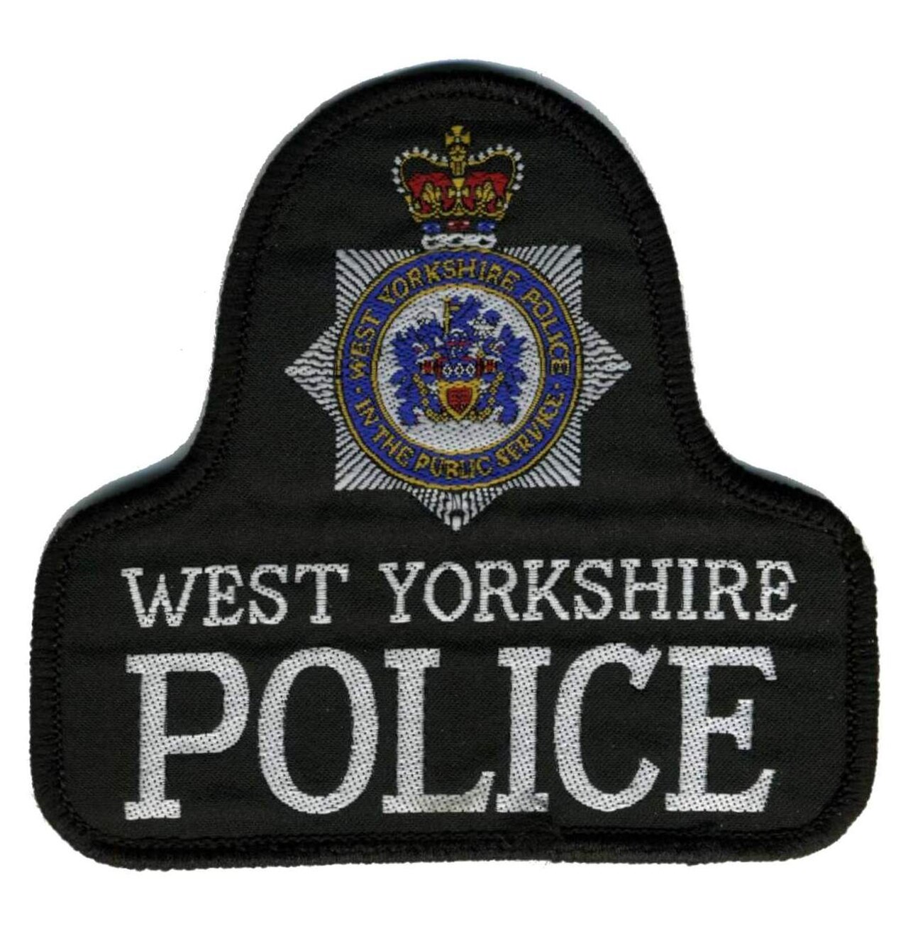 A black police patch with the words "WEST YORKSHIRE POLICE" embroidered in white capital letters. Above the text is a badge with a crown and a star-shaped emblem containing the words "WEST YORKSHIRE POLICE IN THE PUBLIC SERVICE".