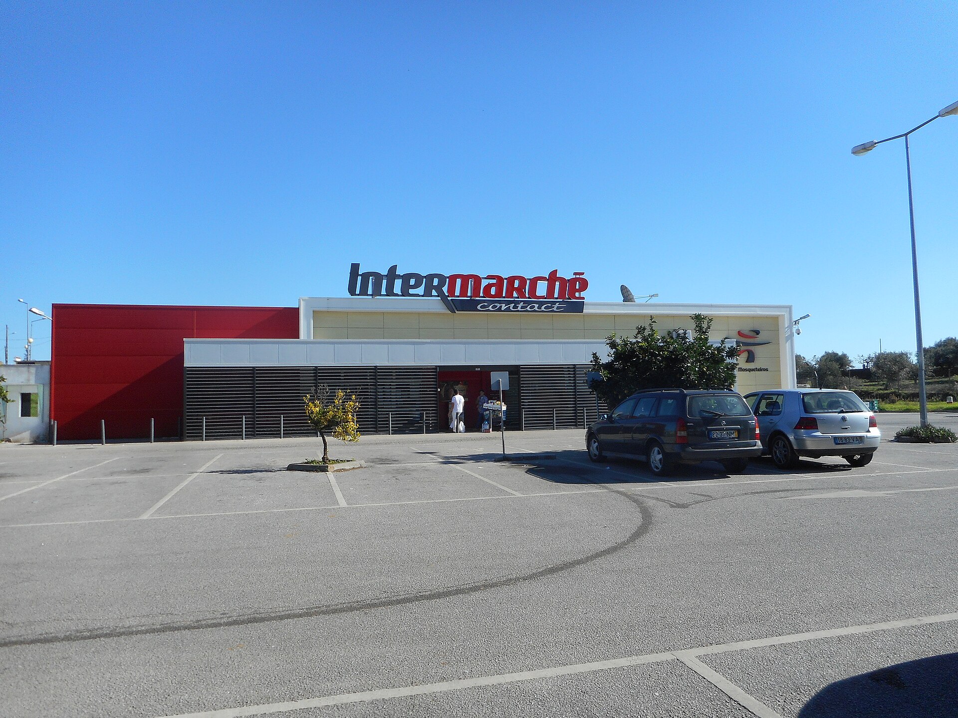 An Intermarché supermarket building with a parking lot and cars.