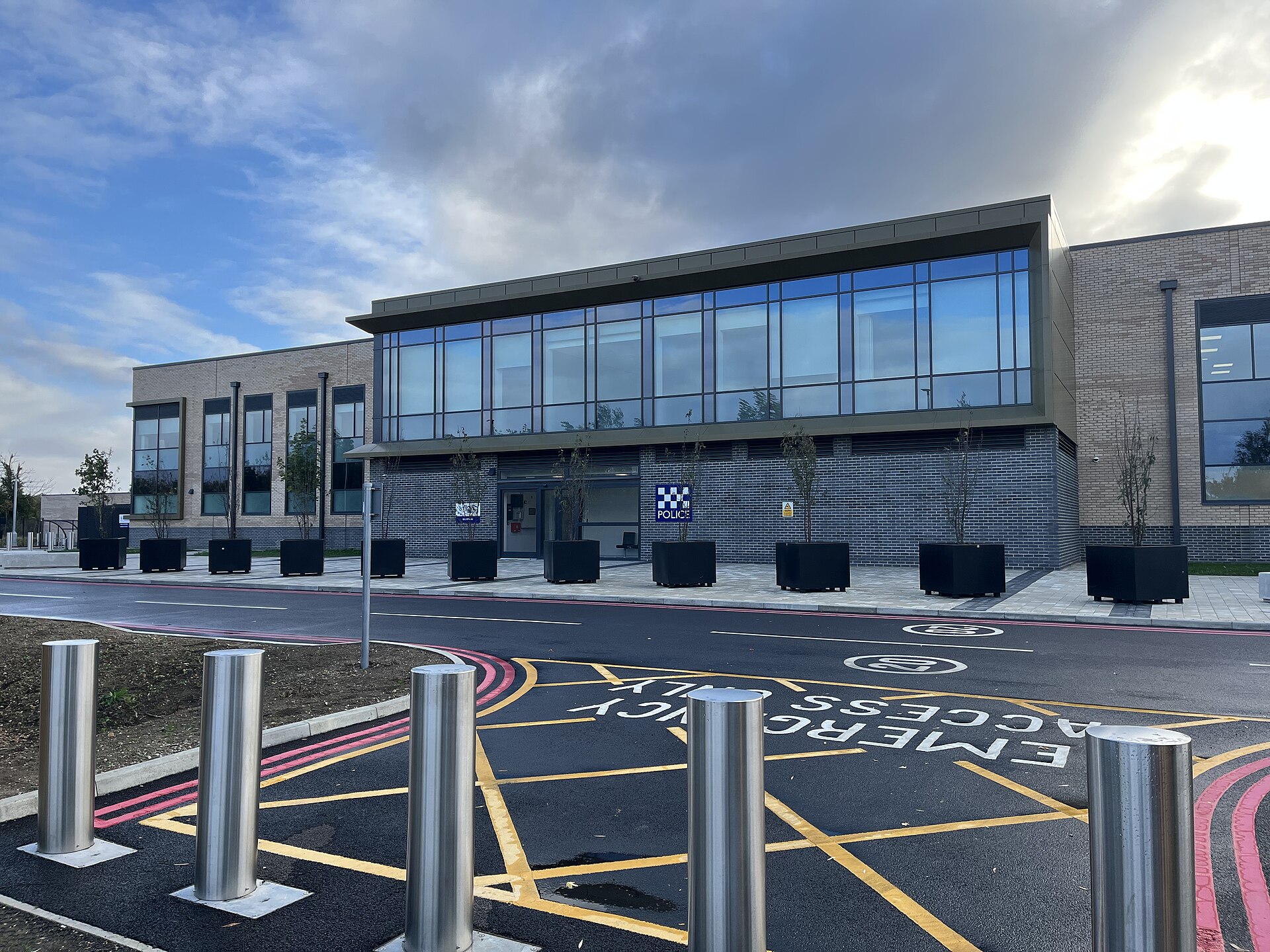A modern brick police station with large windows and a "POLICE" sign above the entrance.
