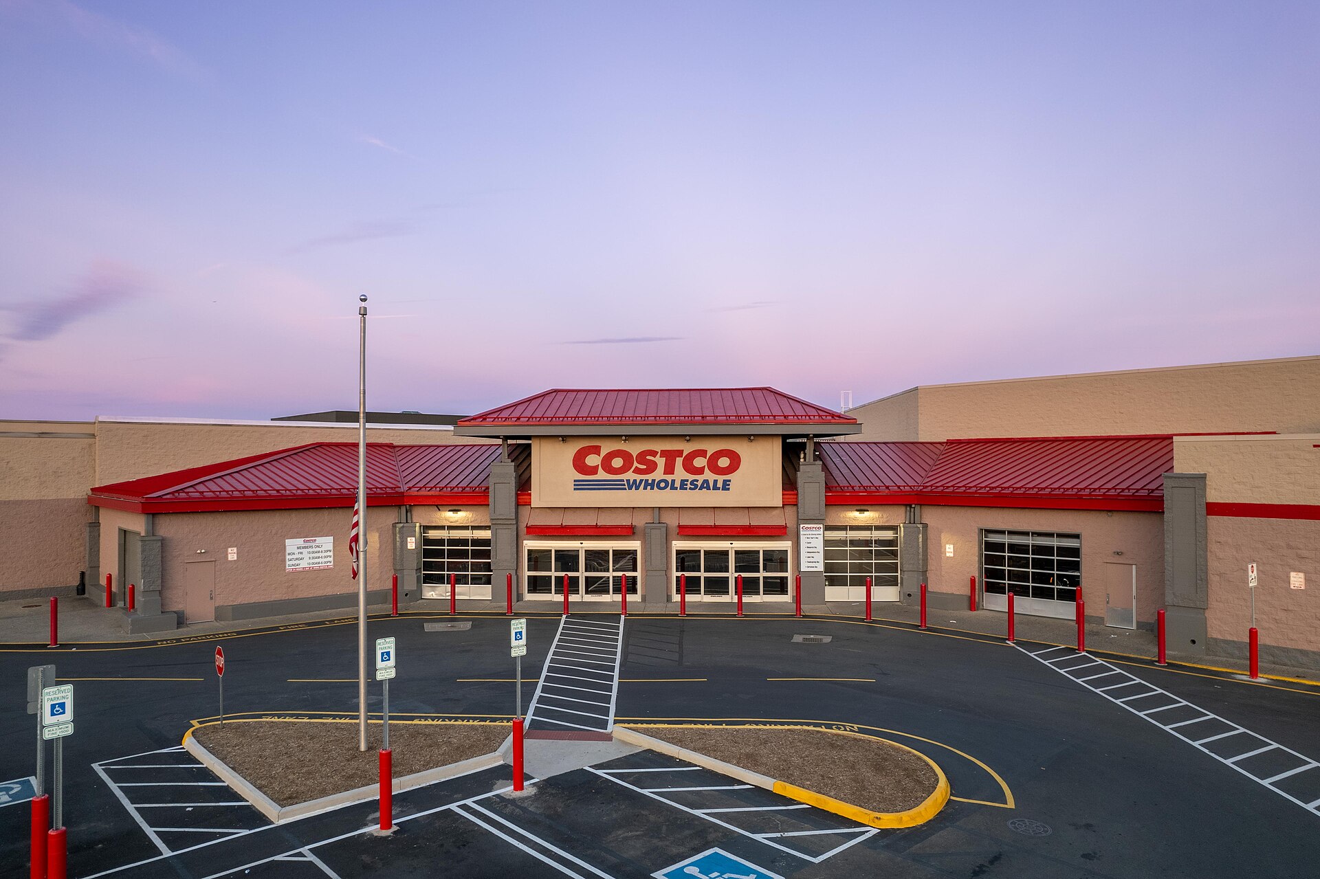 A Costco storefront with a red roof and sign reading 'COSTCO WHOLESALE' above the entrance