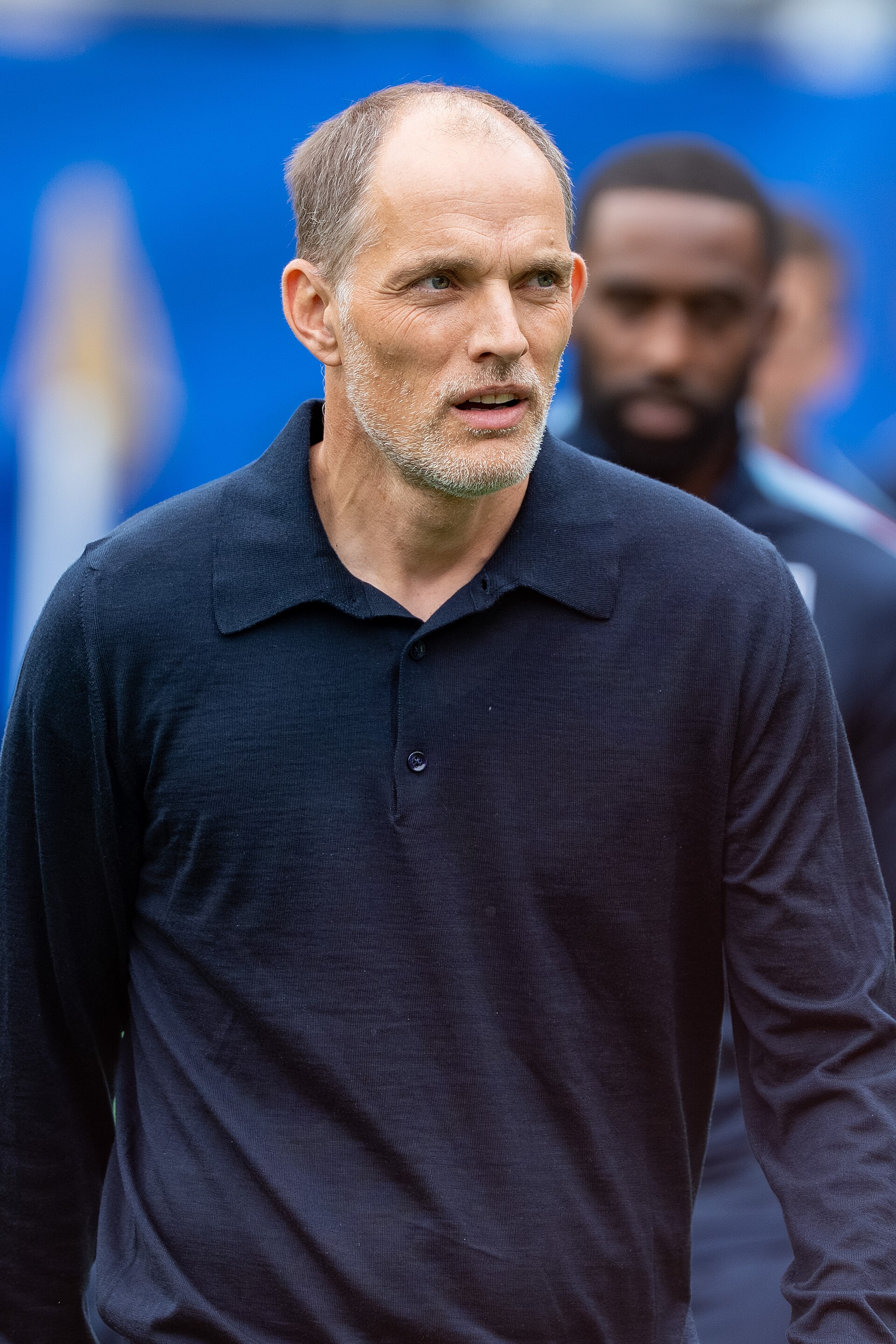 A middle-aged man with short graying hair and a short beard wearing a dark blue polo shirt.