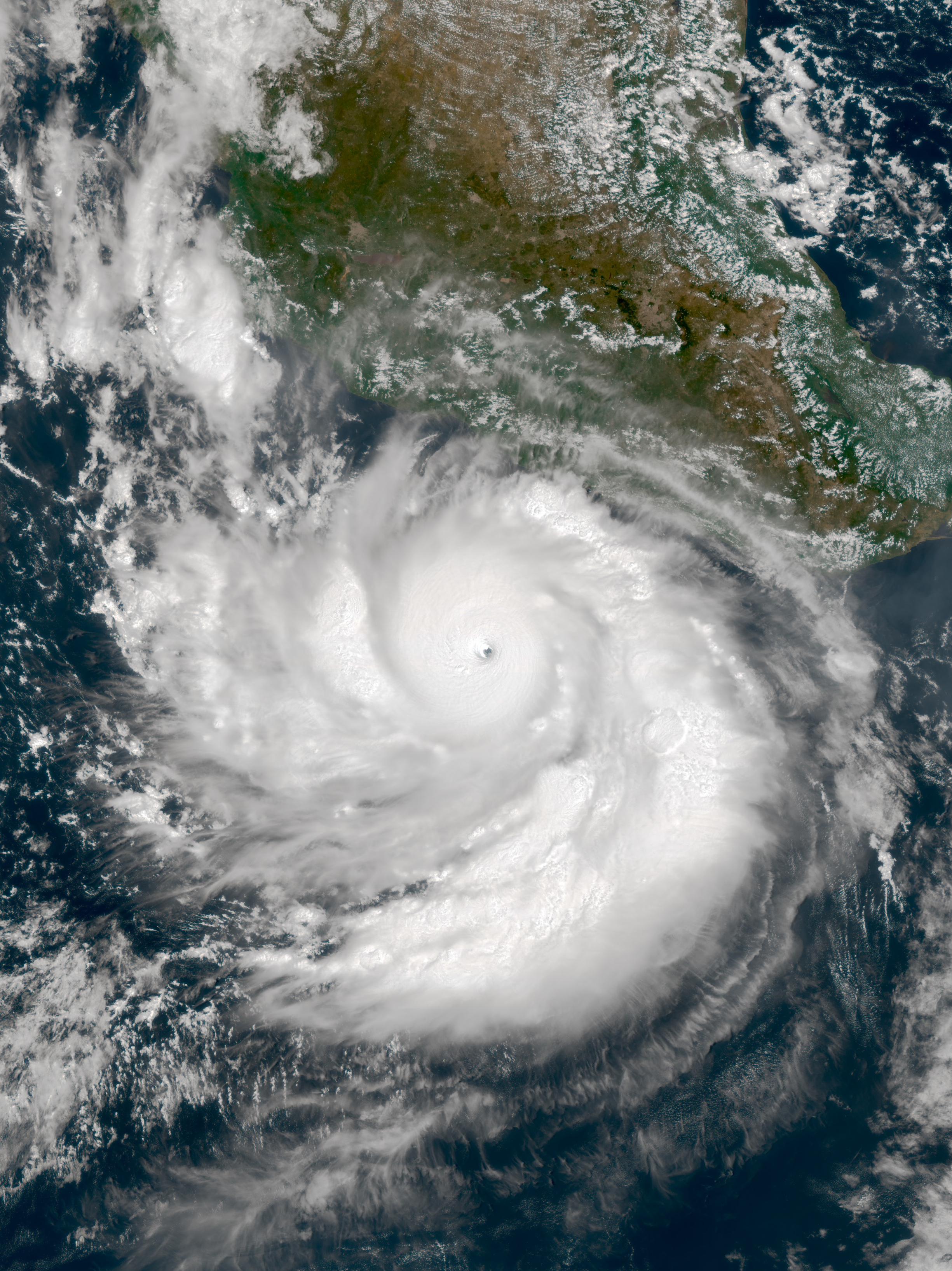 Satellite image of a large hurricane over the ocean, with clouds swirling around the eye.