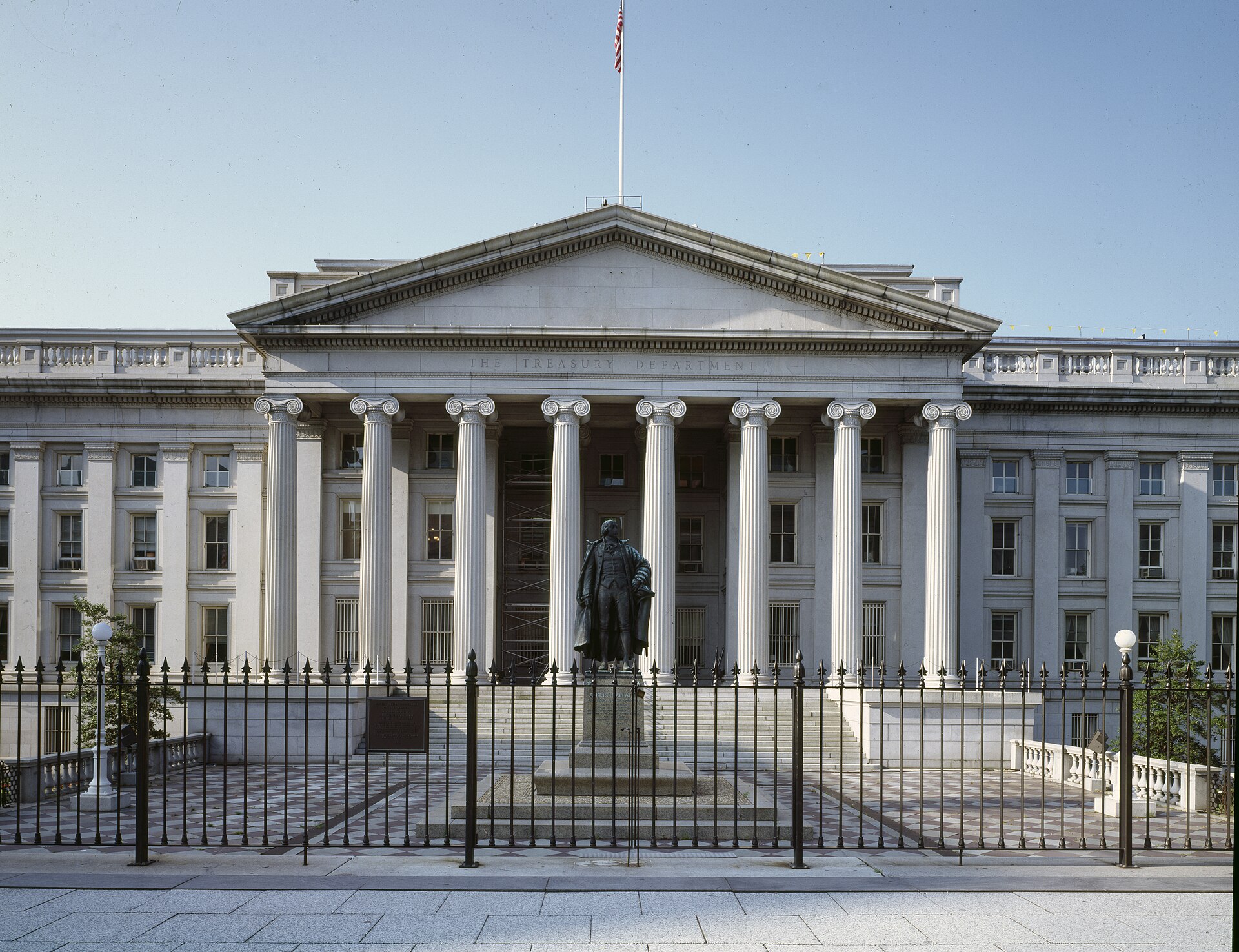 The U.S. Treasury Department building with a statue in front of it.