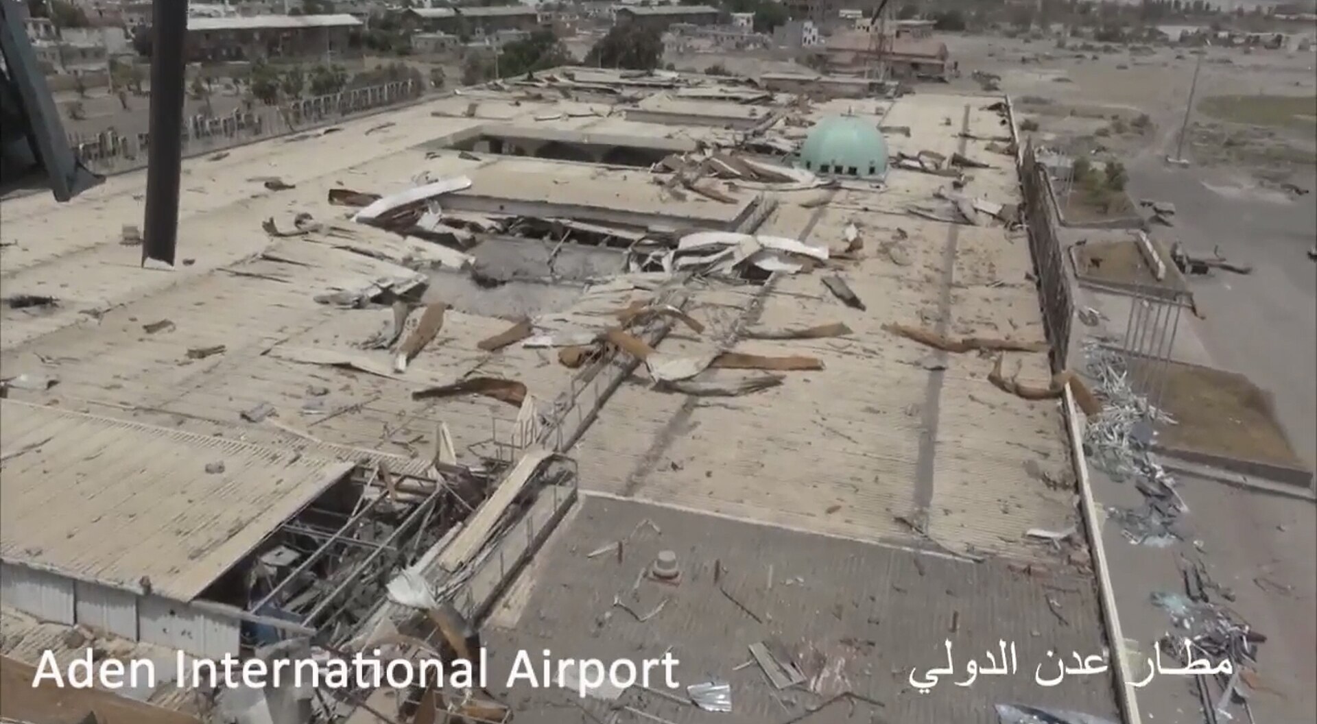Aerial view of damaged building labeled Aden International Airport