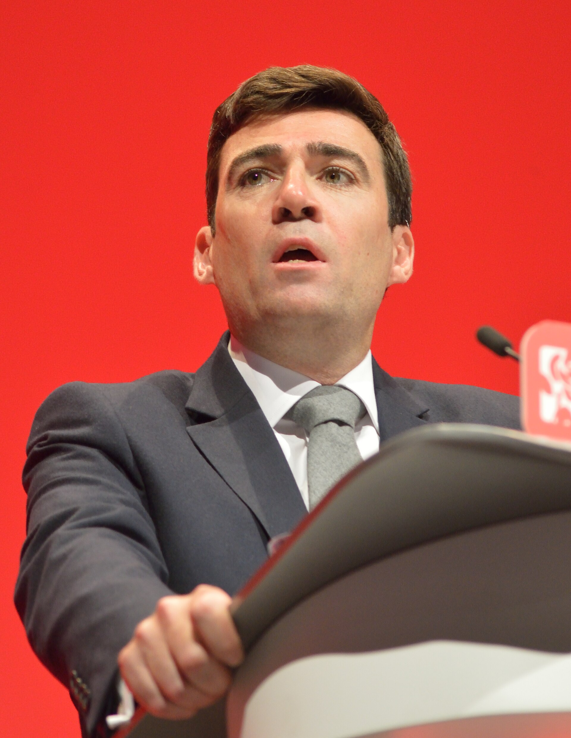 Andy Burnham speaking at a podium
