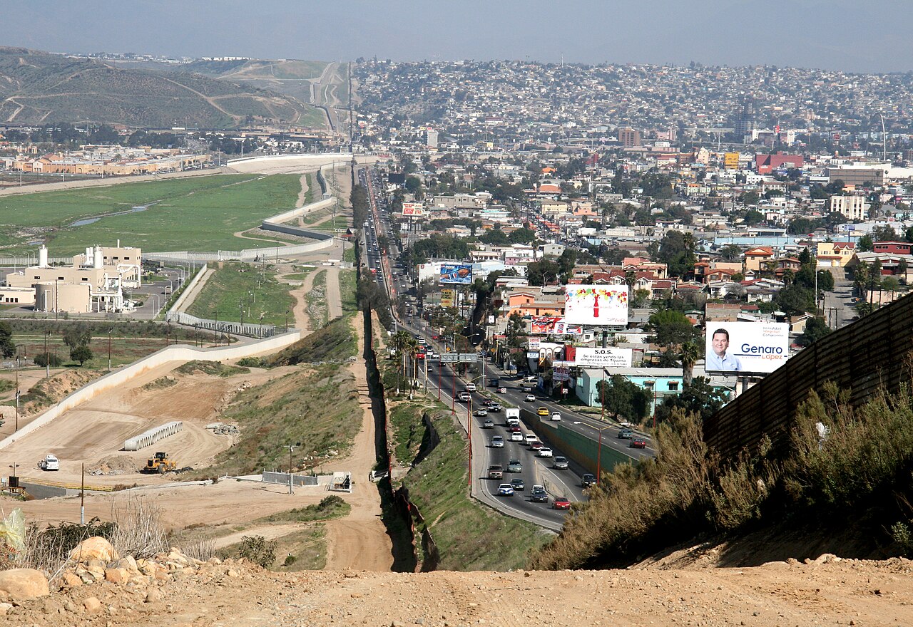 A fence on a hill between Tijuana and the United States, with the Border Patrol sector on the U.S. side.